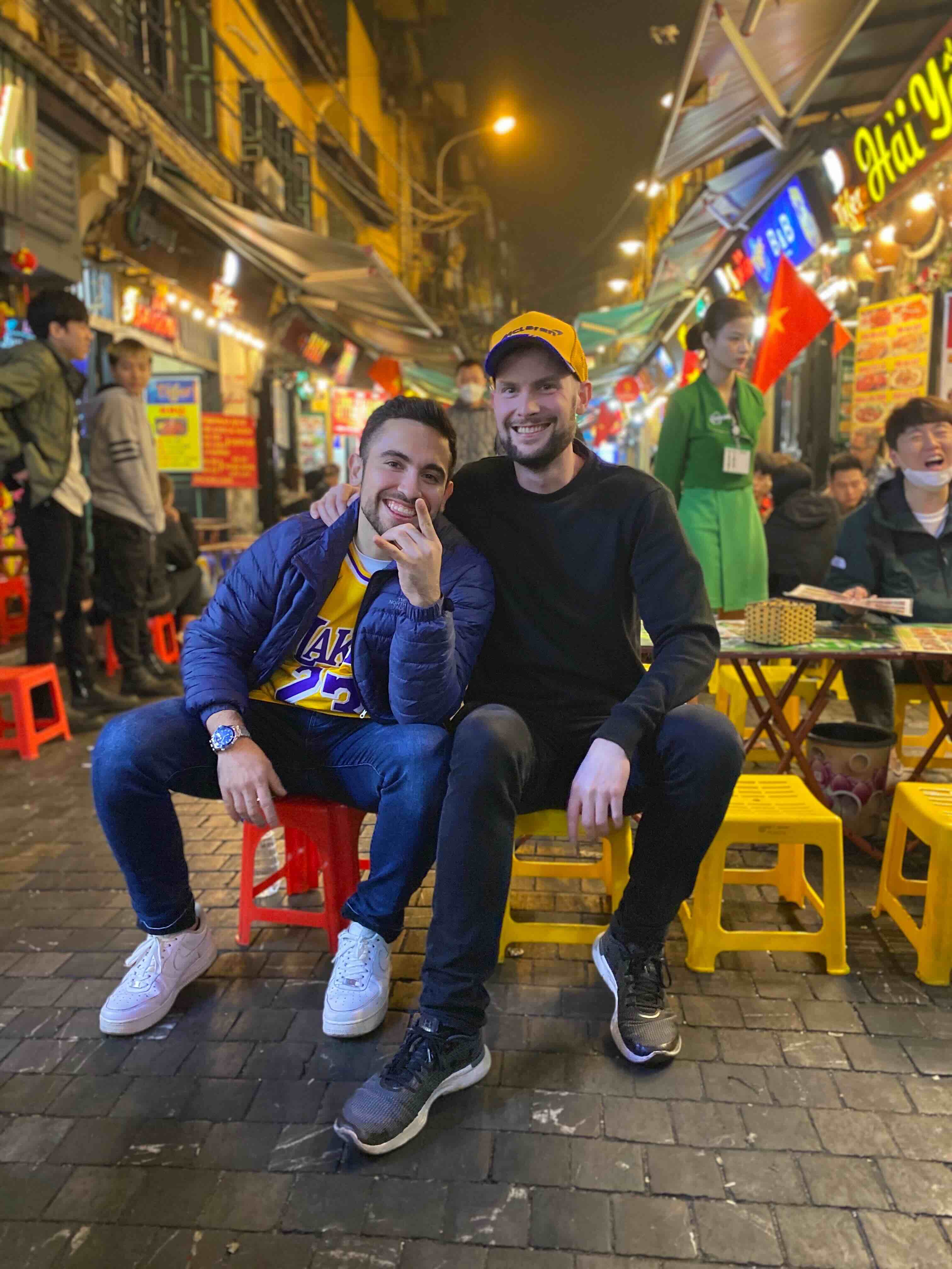 Crowded Beer Street with people sitting on tiny plastic stools